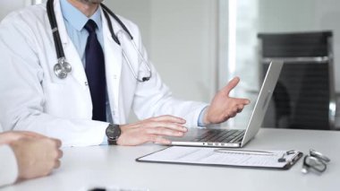 Klinikte tıbbi konsültasyon sırasında hastayla sağlık konusunu tartışan erkek doktor, uzman tavsiyeleri ve tedavi tavsiyeleri sunuyor. Tıp, sağlık ve bilim konsepti