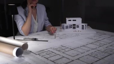 Gece geç saatlere kadar çalışmaktan başı ağrıyan yorgun bir kadın mimar, ofiste kendini stresli ve çok çalışkan hissediyor..