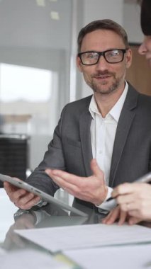 Profesyonel iş adamı ve meslektaşları el çırpıyor, şirket ofisinde yapılan bir iş toplantısında başarı, başarı ve olumlu sonuçlar için takdir ve coşku gösteriyorlar.