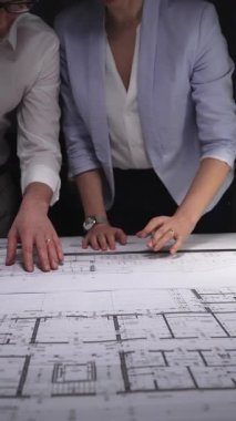 Mühendislik ekibi bina planı tasarlıyor, mimarlar inşaat projesinin detaylarını tartışıyor, geleceği planlıyorlar. Gösterişsiz ışıklandırmada mimari ve iş kavramı