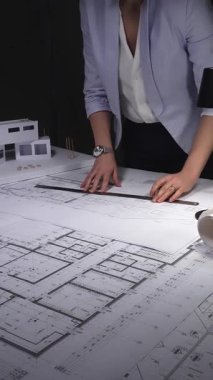 Mimari planlar ve ölçekli modeller üzerinde çalışan kadın mimar, inşaat planlama ve mühendisliğe odaklanıyor. Gösterişsiz ışıklandırmada mimari ve iş konsepti