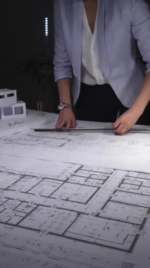 Mimari planlar ve ölçekli modeller üzerinde çalışan kadın mimar, inşaat planlama ve mühendisliğe odaklanıyor. Gösterişsiz ışıklandırmada mimari ve iş konsepti