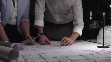 Profesyoneller bina planlarını gözden geçiriyorlar, tasarım hazırlıyorlar ve inşaat projeleri geliştiriyorlar, takım çalışmasını ve adanmışlığı vurguluyorlar..