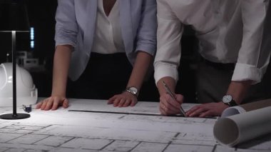 Profesyonel mimarlar ve mühendisler mimari planlar üzerinde birlikte çalışıyor, ofiste yeni inşaat projeleri tasarlıyor ve geliştiriyorlar..