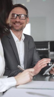 Profesyonel iş adamı ve meslektaşları el çırpıyor, şirket ofisinde yapılan bir iş toplantısında başarı, başarı ve olumlu sonuçlar için takdir ve coşku gösteriyorlar.