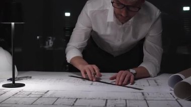 Profesyonel mimar gece geç saatlerde şehir planlarını hazırlıyor, tasarım, planlama ve inşaat detaylarına odaklanıyor. İş ve mimarlık kavramı