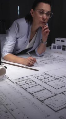 Mimar, el çizimi bir model ve aydınlatma masasındaki aletlerle mimari çizimlere derinden odaklanmıştır. Gösterişsiz ışıklandırmada mimari ve iş konsepti