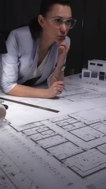 Mimar, el çizimi bir model ve aydınlatma masasındaki aletlerle mimari çizimlere derinden odaklanmıştır. Gösterişsiz ışıklandırmada mimari ve iş konsepti