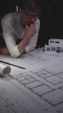 Mimari çizimler, yer planlarını analiz etmek ve yeni bir mimari proje için hacimli bir model oluşturmak. Gösterişsiz ışıklandırmada mimari ve iş kavramı