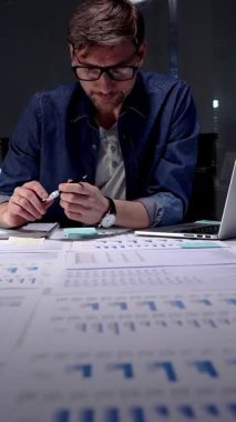 Çok çalışan iş adamı, iş baskısı ve stresiyle boğuşuyor, geç saatlere kadar loş bir ofis ortamında çalışırken yorgunluk ve hüsrandan muzdarip, tükenmiş ve baş ağrısı çekiyor.