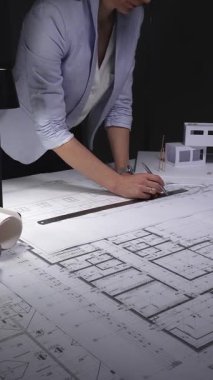 Mimari planlar ve ölçekli modeller üzerinde çalışan kadın mimar, inşaat planlama ve mühendisliğe odaklanıyor. Gösterişsiz ışıklandırmada mimari ve iş konsepti