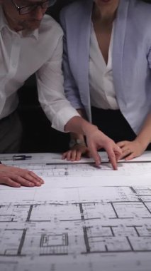 Mühendislik ekibi bina planı tasarlıyor, mimarlar inşaat projesinin detaylarını tartışıyor, geleceği planlıyorlar. Gösterişsiz ışıklandırmada mimari ve iş kavramı