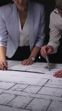 Mühendislik ekibi bina planı tasarlıyor, mimarlar inşaat projesinin detaylarını tartışıyor, geleceği planlıyorlar. Gösterişsiz ışıklandırmada mimari ve iş kavramı