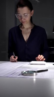 İş kadını geç saatlere kadar kalıyor, finans hesapları yapıyor, vergi evraklarına ve lambalı yasal belgelere odaklanıyor. İş dünyasında denetim ve vergi teması