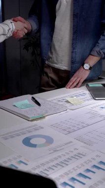 Ekonomik strateji üzerinde işbirliği yapan iş ortakları, modern bir çalışma alanında anlaşma imzalamak için el sıkışmak, belgeler ve tablet üzerindeki verileri gözden geçirmek, gelecekteki büyüme için bir anlaşmanın doğrulanması