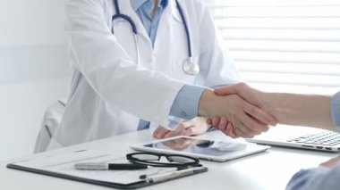 Sıcacık tokalaşan, tedaviyi sürdüren ve klinik ortamda terapötik ilişki kuran tıbbi profesyonel bir hasta. İlaç ve sağlık hizmetleri