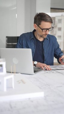 Mimari bir model üzerinde çalışan, yeni inşaat projeleri tasarlayan ve planlayan, modern inşaat fikirleriyle modern ofis ortamında planlar ve şehir kavramları geliştiren bir mimar.