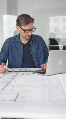 Mimari bir model üzerinde çalışan, yeni inşaat projeleri tasarlayan ve planlayan, modern inşaat fikirleriyle modern ofis ortamında planlar ve şehir kavramları geliştiren bir mimar.