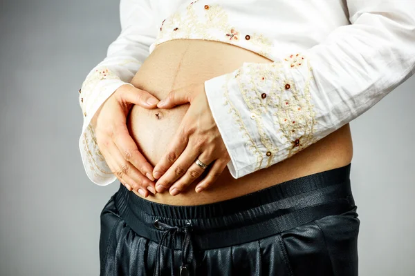 Mulher grávida criando forma de coração na barriga — Fotografia de Stock