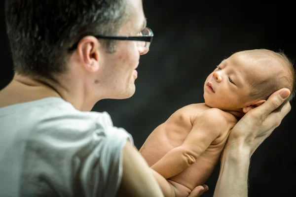 Feliz padre sosteniendo con amor a su hijo recién nacido — Foto de Stock