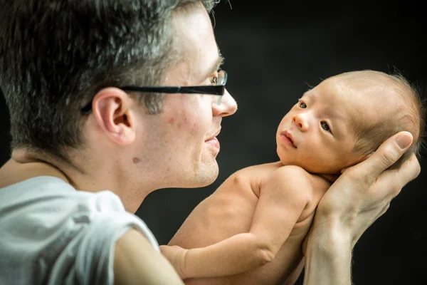 Glücklicher Vater, der seinen neugeborenen Sohn liebevoll hält — Stockfoto