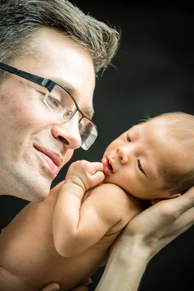 Feliz padre sosteniendo con amor a su hijo recién nacido — Foto de Stock