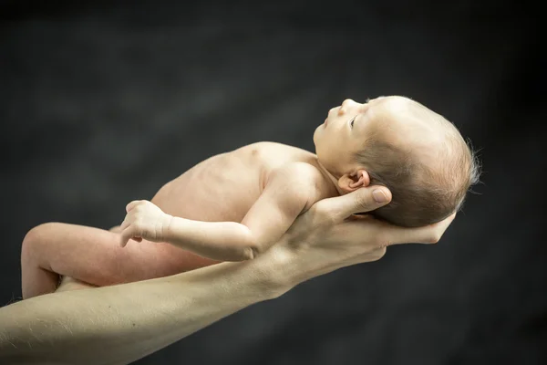 Infant resting on his father's hand — Stock Photo, Image