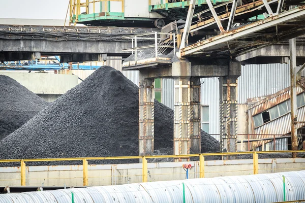 Tas de charbon dans la mine parmi les infrastructures minières — Photo
