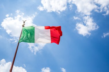 Mavi gökyüzünde sallanan İtalyan bayrağı.