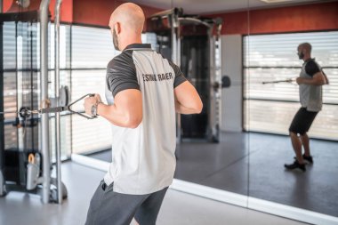 Spor salonunda traktör kullanarak egzersiz yapan özel antrenör.