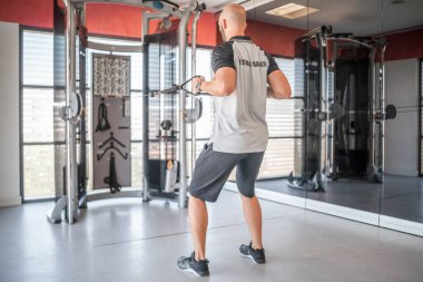 Spor salonunda traktör kullanarak egzersiz yapan özel antrenör.