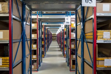 Mallarla dolu büyük, modern bir depoda uzun bir koridor.