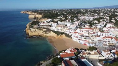 Sahil ve yamaçlardaki geleneksel Portekiz köyünün havadan görünüşü, Carvoeiro, Algarve, Portekiz