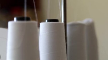 Dikiş makinesindeki ipliği bağlayan kadın