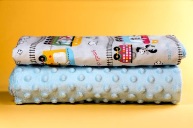 Sarı arka planda tren desenli şirin ve rahat bir bebek battaniyesi.