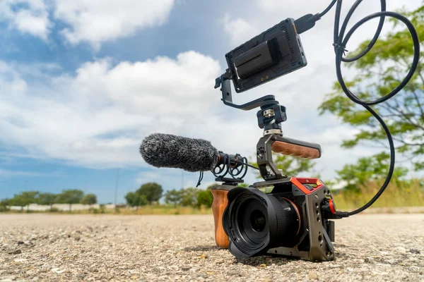 Full frame camera with external monitor, mic, and handheld film-making rig.