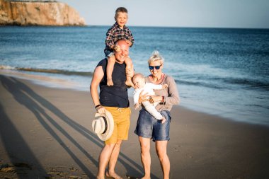 İki küçük çocukla birlikte Algarve, Portekiz sahilinde eğlenen aile.