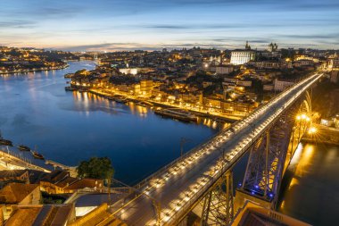 Portekiz 'de gece vakti ünlü köprüsü olan tarihi Porto şehrinin silueti.