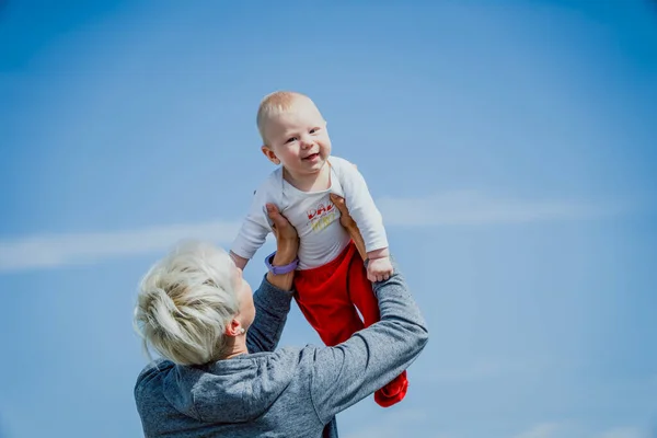 Bionda Madre Tenendo Suo Figlio Mezzo Anno Contro Cielo Blu — Foto Stock