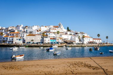 Ferragudo şehrinin ön planda beyazlatılmış mimarisi ve tekneleri, Algarve, Portekiz