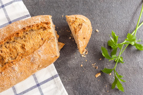 Tasty bread sliced on kitchen towel — Stock Photo, Image