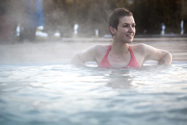 Mujer joven relajándose en la piscina termal . —  Fotos de Stock