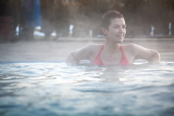 Mujer joven relajándose en la piscina termal . —  Fotos de Stock