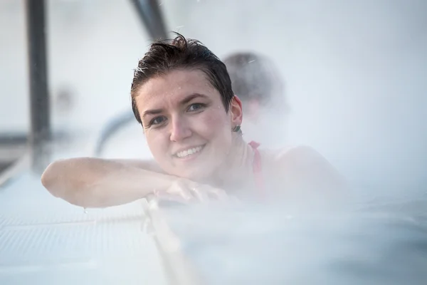 Mujer joven relajándose en la piscina termal . — Foto de Stock