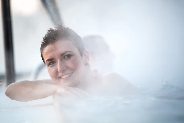 Mujer joven relajándose en la piscina termal . —  Fotos de Stock