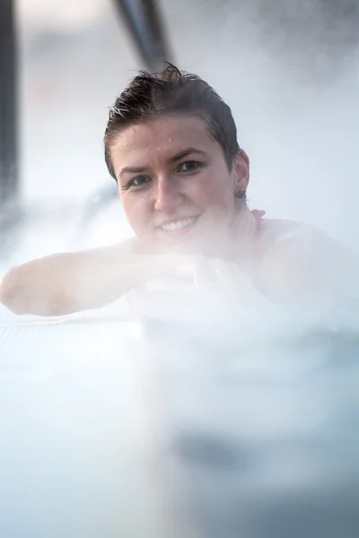 Mujer joven relajándose en la piscina termal . — Foto de Stock