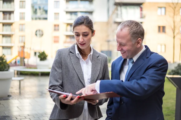 Twee mensen uit het bedrijfsleven bespreken buiten het kantoor — Stockfoto