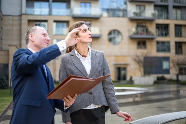 Hombre y mujer mirando y señalando hacia arriba — Foto de Stock