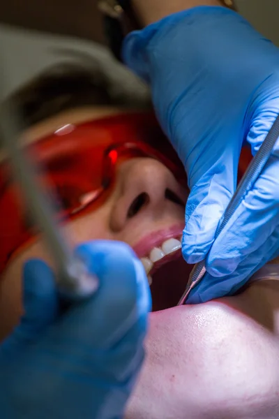 Patiënt in het kantoor tandarts - echte werken. — Stockfoto