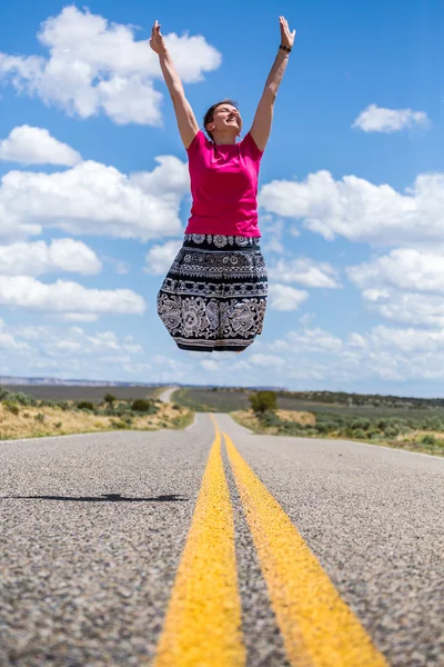 Glückliche Frau springt über amerikanische Straße — Stockfoto